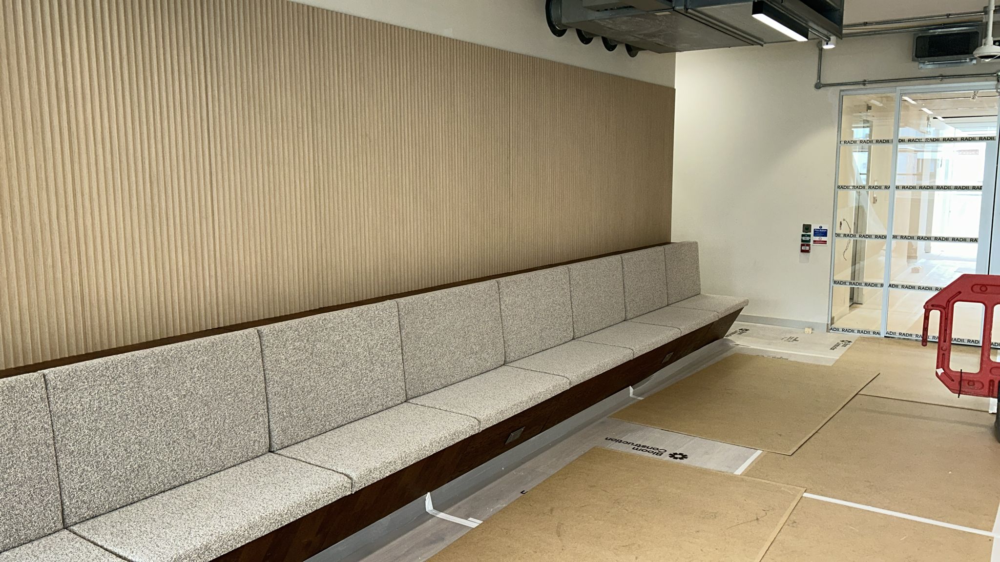 Bespoke banquette seating against full-height oak fluted acoustic panels